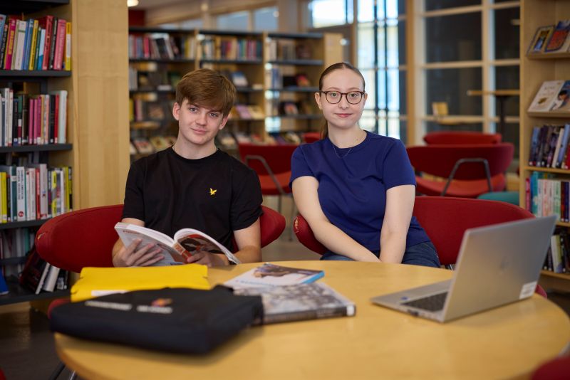 Tre elever som pluggar i biblioteket.